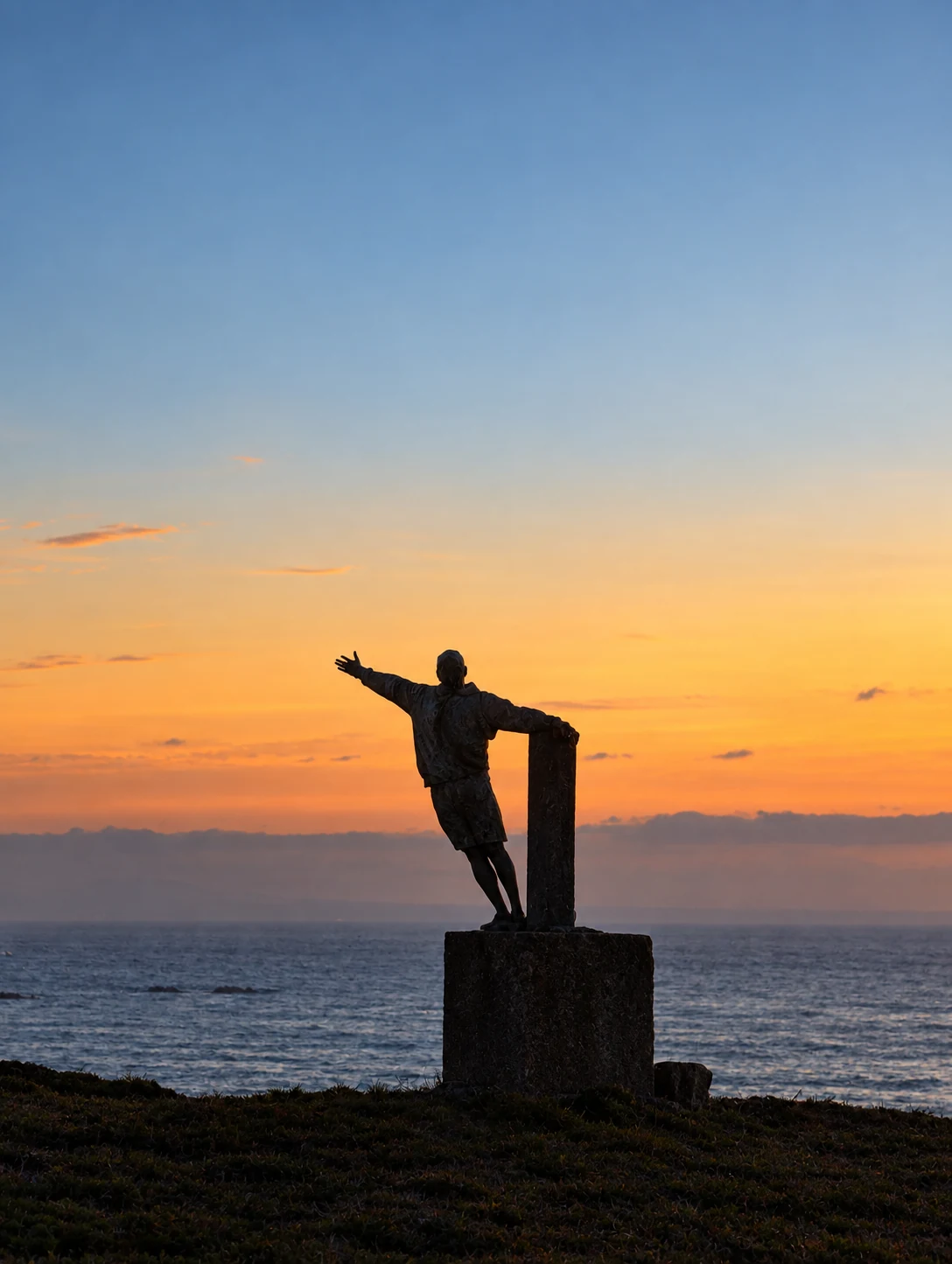 Escultura frente al mar al atardecer, imagen vinculada al recorrido personal de Leonardo Moscoso